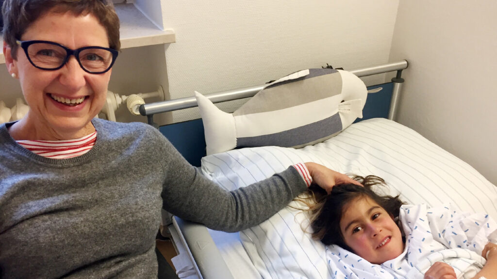 Die Hamburger Gastmutter Brigitte Eichholz sitzt nach der Herz-OP am Krankenhausbett der sechsjährigen Afghanin Aisha
