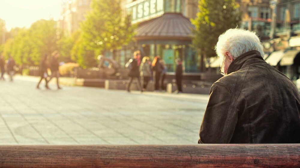 Alter Mann, der auf einer Bank sitzt