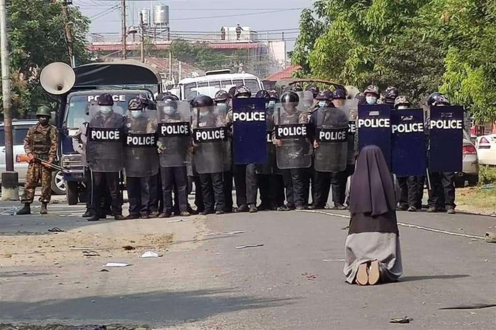 Eine Ordensschwester in Myanmar betet vor dem Polizeiaufgebot