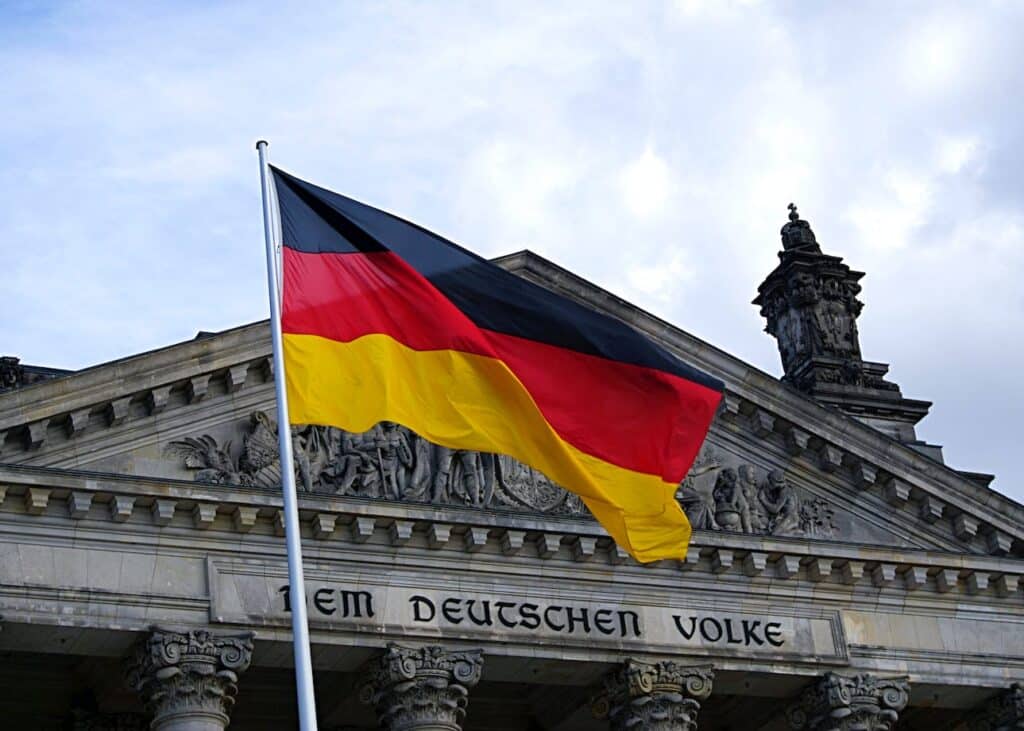 Deutsche Flagge vor dem Reichtagsgebäude in Berlin. Die Inschrift auf dem Archivtrav "Dem Deutschen Volke" ist zu sehen.