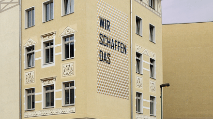 „Wir schaffen das“, Zitat an Hauswand